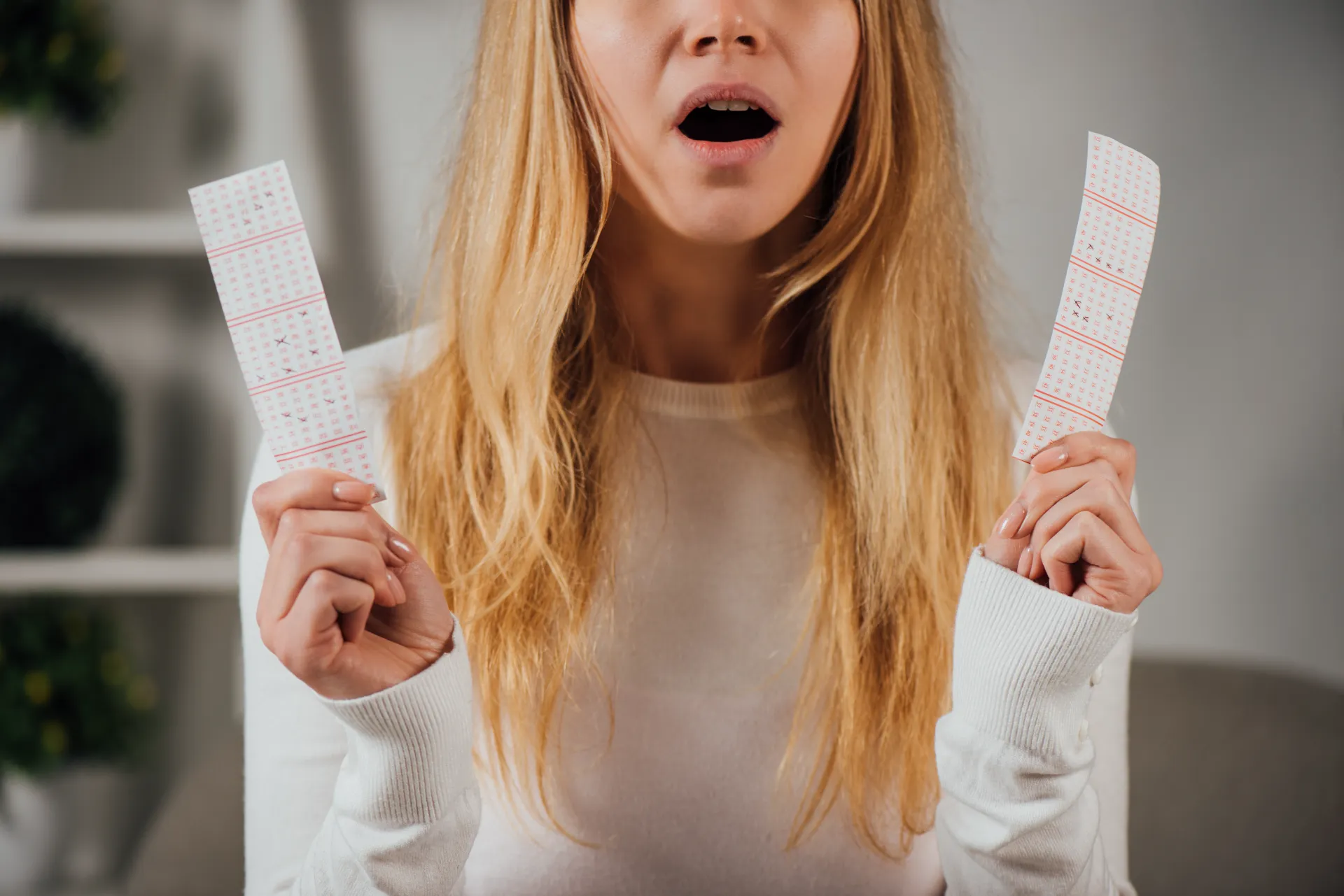 a lady holding two tickets with bonus number and won mega millions against the odds. her chances of winning from one ticket have happened right on point.